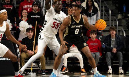 Bryant Bulldogs guard Earl Timberlake (0) handles the ball as Cincinnati Bearcats forward Aziz Bandaogo (55) guards him in the first half of the NCAA Basketball game between the Bryant Bulldogs and Cincinnati Bearcats at Fifth Third Arena in Cincinnati on Tuesday, Dec. 12, 2023.